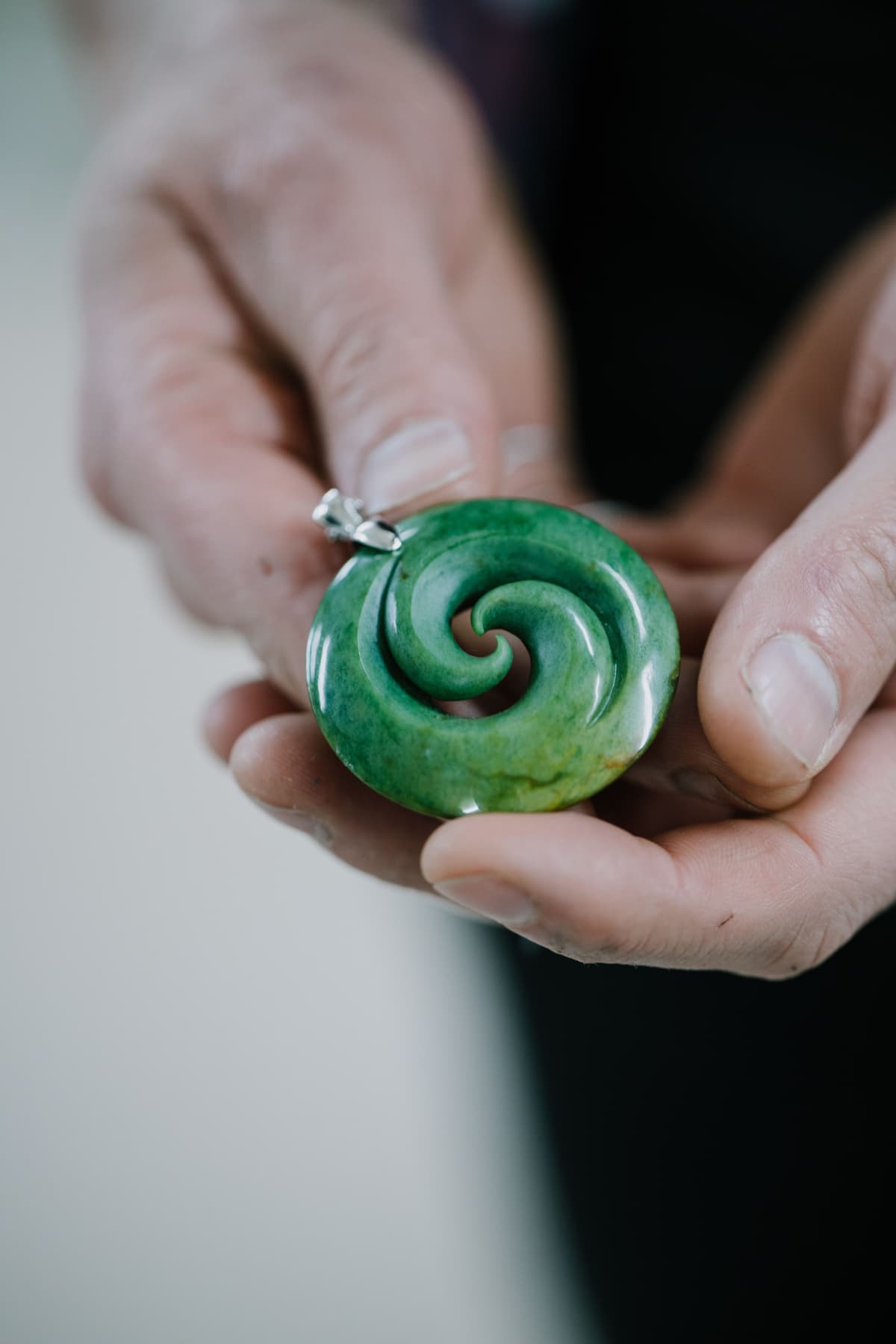 Contemporary Māori koru jewellery hand-carved from authentic New Zealand pounamu and finished with a silver setting, its flowing spiral form expressing growth, renewal and connection.